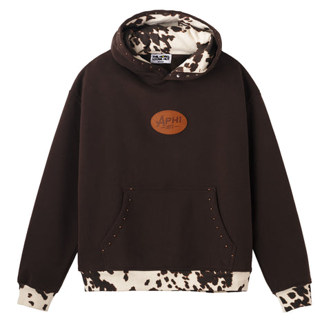 Brown hoodie with cow print cuffs and hem with 'APHI' leather patch on chest and copper studs along pocket and hood on a white background