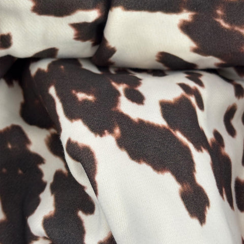 Close-up of fabric with a brown and white cow print pattern